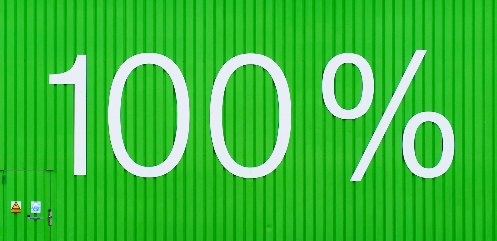 white lettering saying "100%" on a green wall